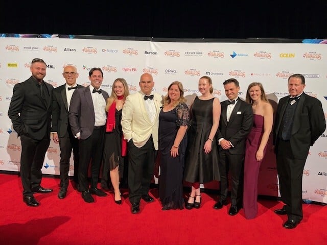 The NSG team dressed in formal attire posing together on a red carpet at an event.